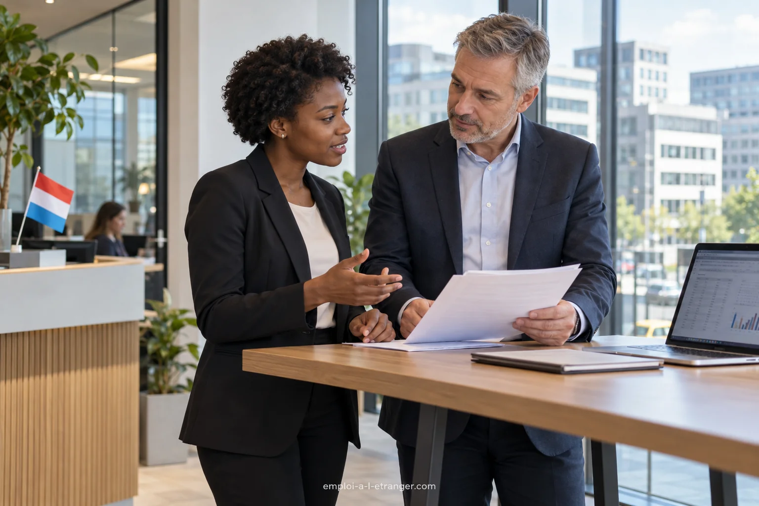 Analyst discussing work with a colleague in a Luxembourg office